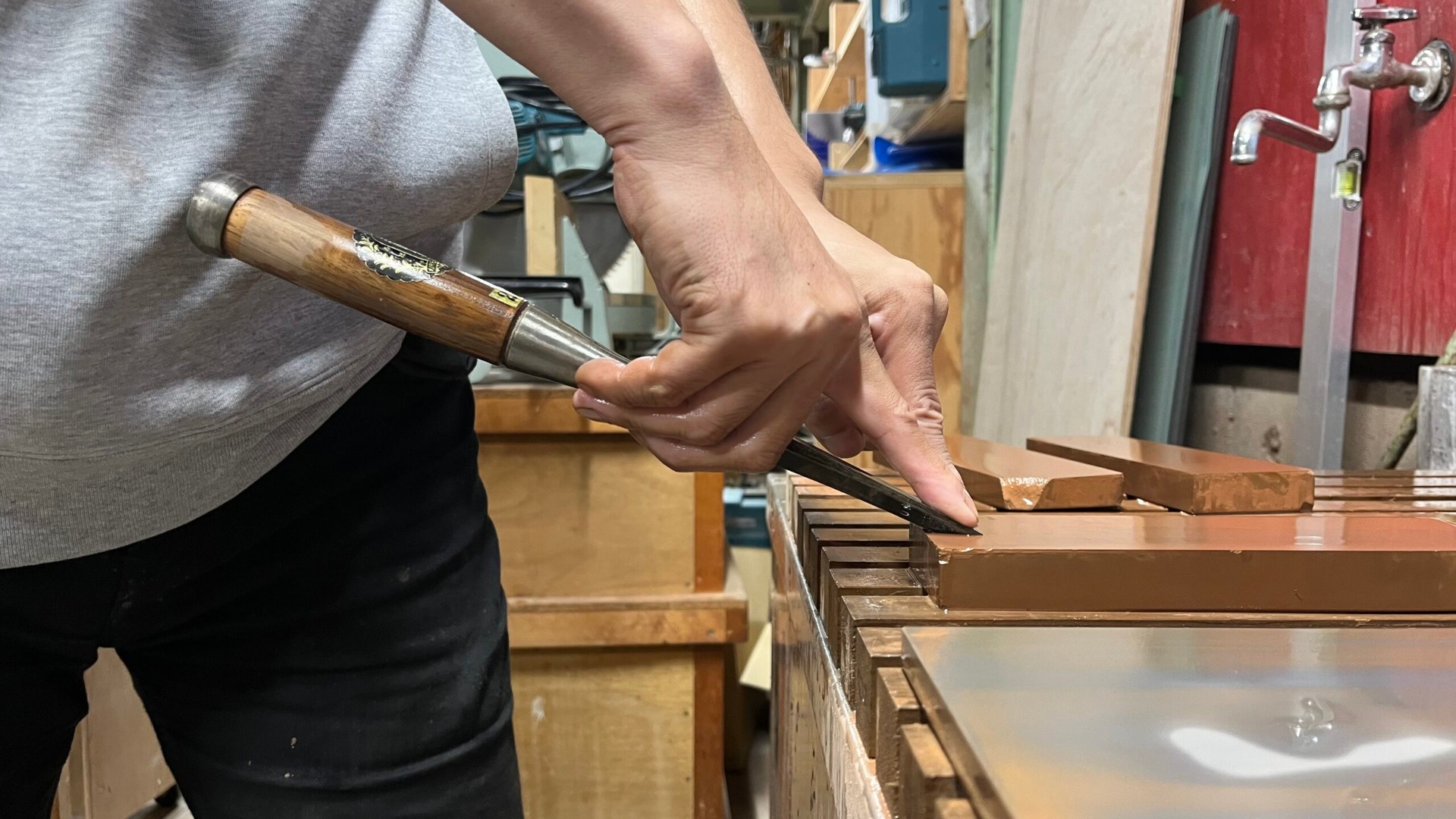 Hands paring with a Japanese chisel